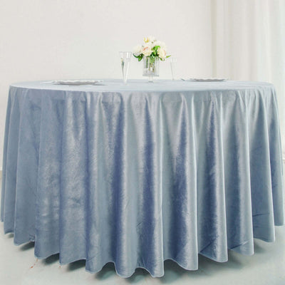Round blue tablecloth draped elegantly over a table with floral centerpiece.