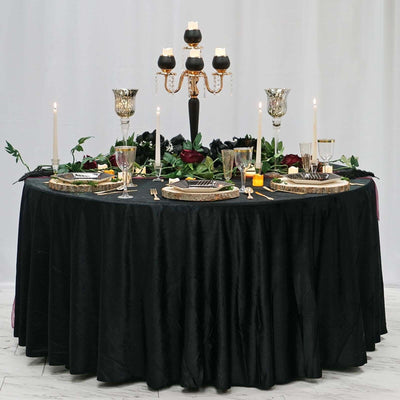 Elegant black table setting with candles and floral decor for a sophisticated dining experience.
