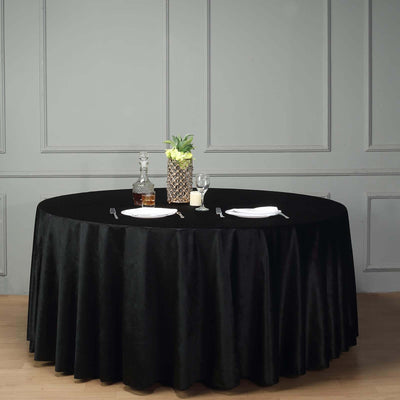 Elegant black round tablecloth with a decorative centerpiece and tableware.