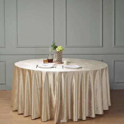 Elegant round table with a gold tablecloth set for dining.