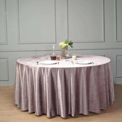 Elegant round table covered with a soft, lavender tablecloth set for dining.
