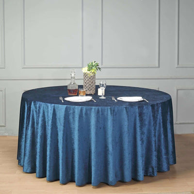 Elegant navy blue tablecloth draped over round table set for dining.