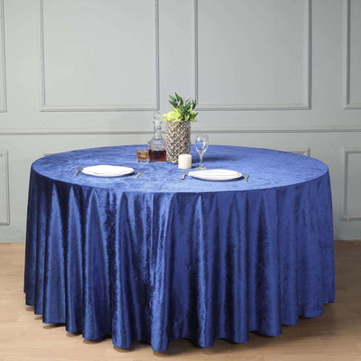 Round blue tablecloth draped over a table set for dining.