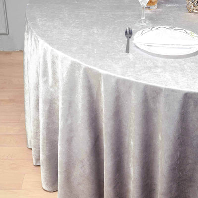 Elegant silver tablecloth draping over a round table in a stylish setting.