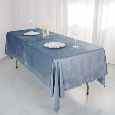 Elegant blue tablecloth draped over a dining table with floral centerpiece and wine glasses.