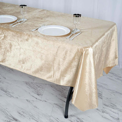 Gold tablecloth draped over a table set with plates and glasses.