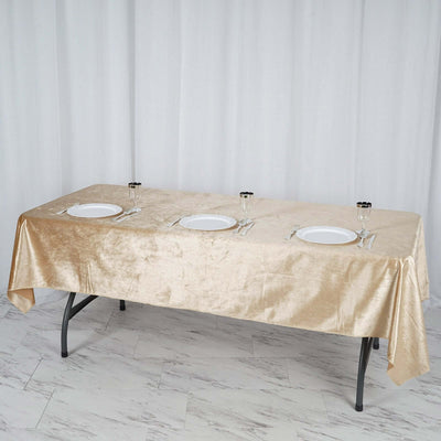 Elegant gold tablecloth draped over a table set with plates and glasses.