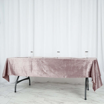Elegant pink tablecloth draped over a table with clear glasses on a white backdrop.