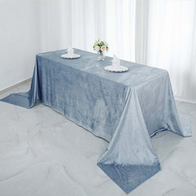Elegant blue tablecloth draped over a table with napkins and flowers.