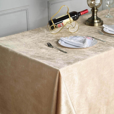 Elegant gold tablecloth draped over a dining table setting with wine and tableware.
