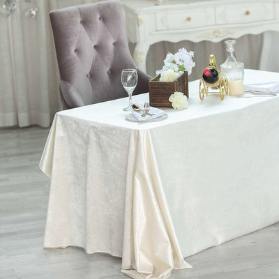 Elegant dining setup with a white tablecloth, wine, and floral decor.
