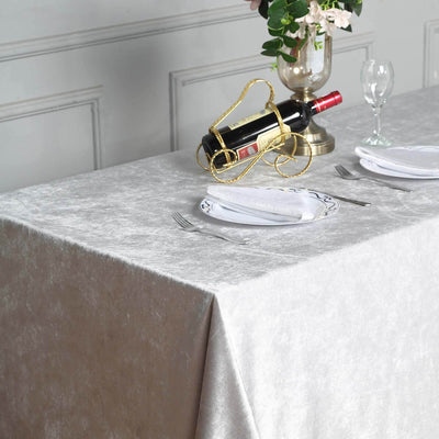 Elegant dining table set with wine, glass, and plates on a textured gray tablecloth.