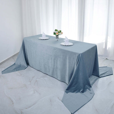Elegant gray tablecloth draped on a dining table with flowers and plates.