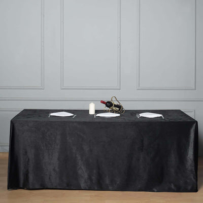 Elegant black tablecloth draped over a table set for dining.