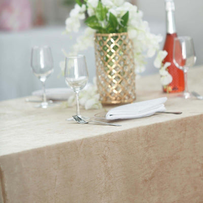 Elegant dining setup with floral centerpiece and wine on a table.