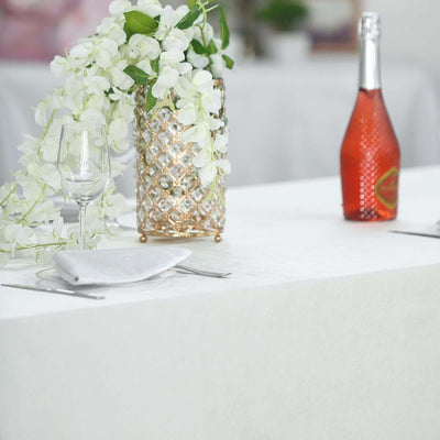 Elegant dining table setting with flowers, glassware, and sparkling beverage.