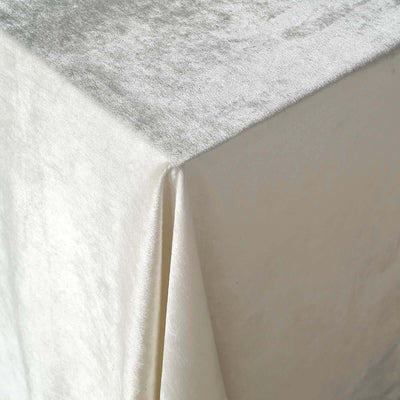 Elegant white velvet tablecloth draping gracefully over a table corner.
