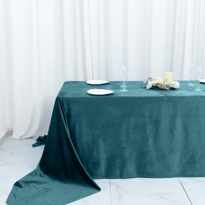 Teal velvet tablecloth draped elegantly over a table with dinnerware.