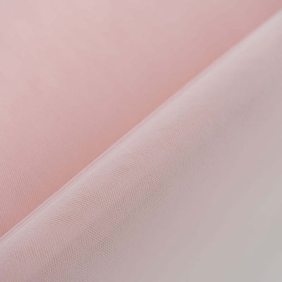 Pink tulle fabric with a soft texture, ideal for crafts and apparel.