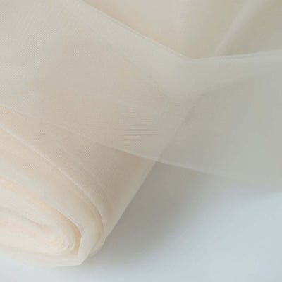 Roll of sheer fabric in soft beige tones.
