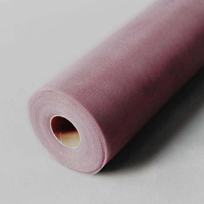 Roll of soft pink tulle fabric on a gray backdrop