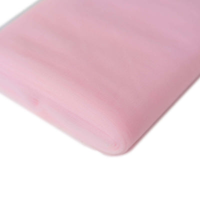 Pink tulle fabric roll on a white background