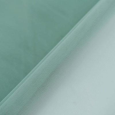 Light green mesh fabric roll on a smooth surface.