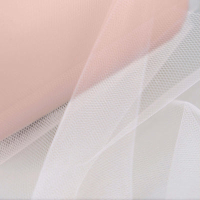 Soft pink and white tulle fabric layers on a neutral background.