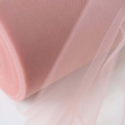 Pink tulle fabric roll on a white background