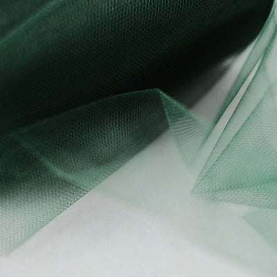 Green tulle fabric draping softly on a white background.