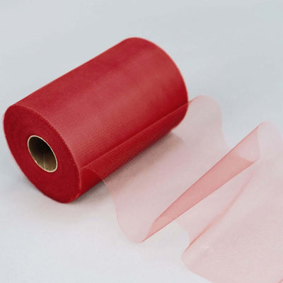 Red tulle roll with sheer fabric unrolling from the spool