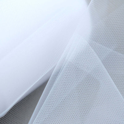 White textured fabric with a hexagonal pattern.