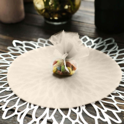 Decorative tulle pouch filled with colorful candies on a lace placemat.