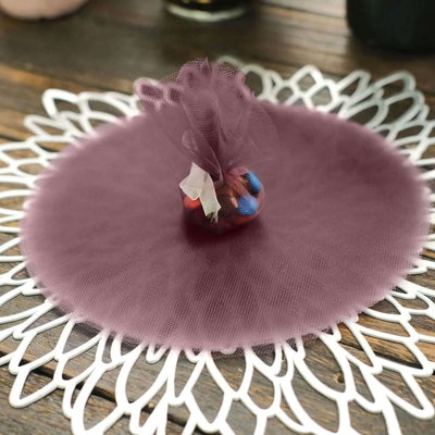 Purple tulle fabric with decorative candy bag on a lace placemat.