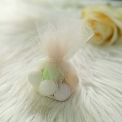 Pastel-colored candy in a mesh bag on soft fur background.