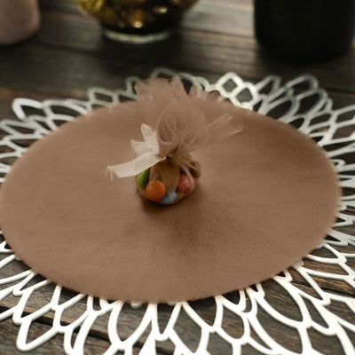 Brown round table mat with a decorative pouch of candies on a wooden surface.