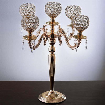 Elegant gold candelabra with crystal globe holders and intricate design.