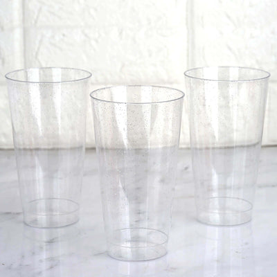 Set of three clear plastic cups on a marble surface.