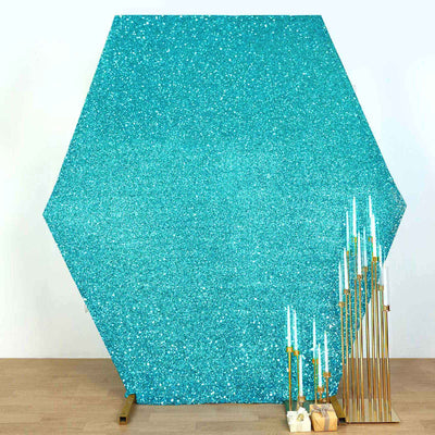 Turquoise glitter backdrop with gold candle holders and teal candles.