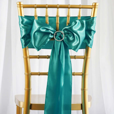 Teal satin chair bow with rhinestone ring on a gold chiavari chair.
