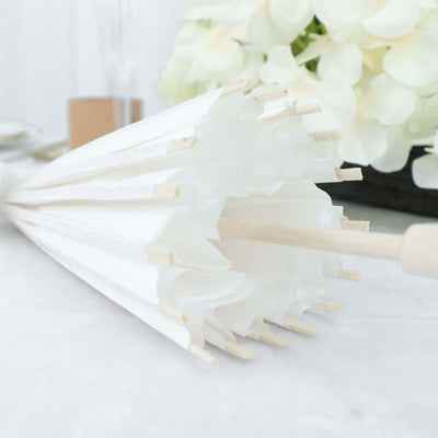 White umbrella with wooden handle and ribs, arranged elegantly.