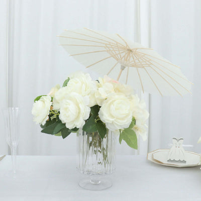 White rose bouquet with a decorative parasol in a clear vase.