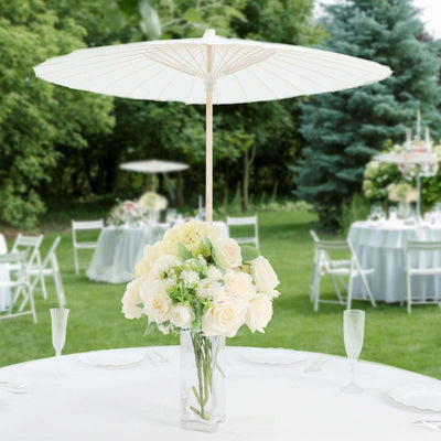 White parasol over floral centerpiece at an outdoor event.