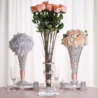 Elegant floral arrangement with roses and pearls in decorative vases.