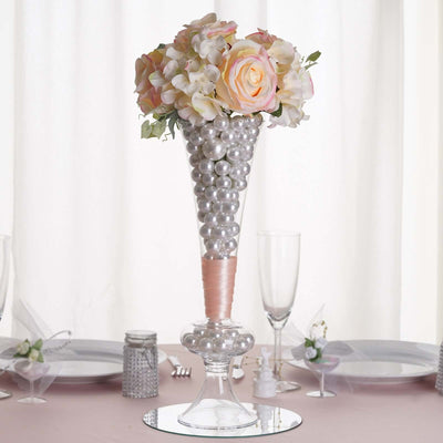 Floral centerpiece with pink roses and pearls in a cone vase