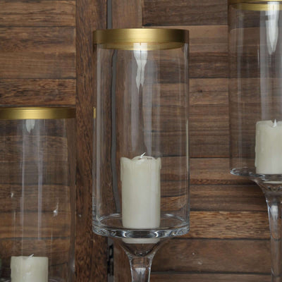 Elegant glass candle holders with gold accents and white candles.