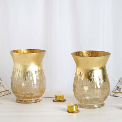 Gold decorative vases with a textured finish, displayed on a light surface.
