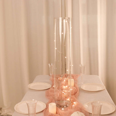 Clear glass vase with fairy lights on a beautifully set dining table.