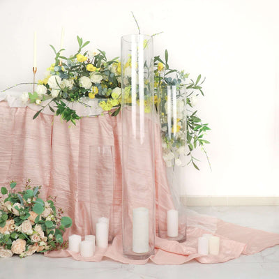 Elegant glass candle holders with white candles and floral arrangements.