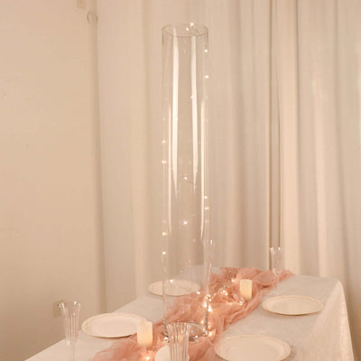 Glass vase with fairy lights on a decorated table setting.